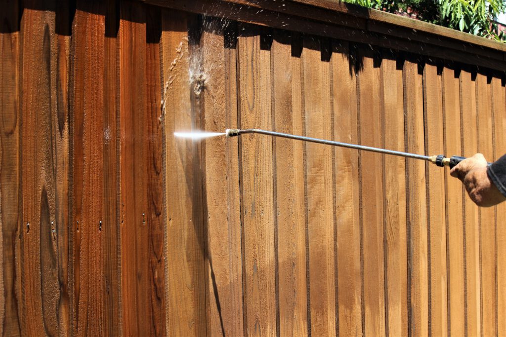 Low-pressure washing a cedar fence during prep