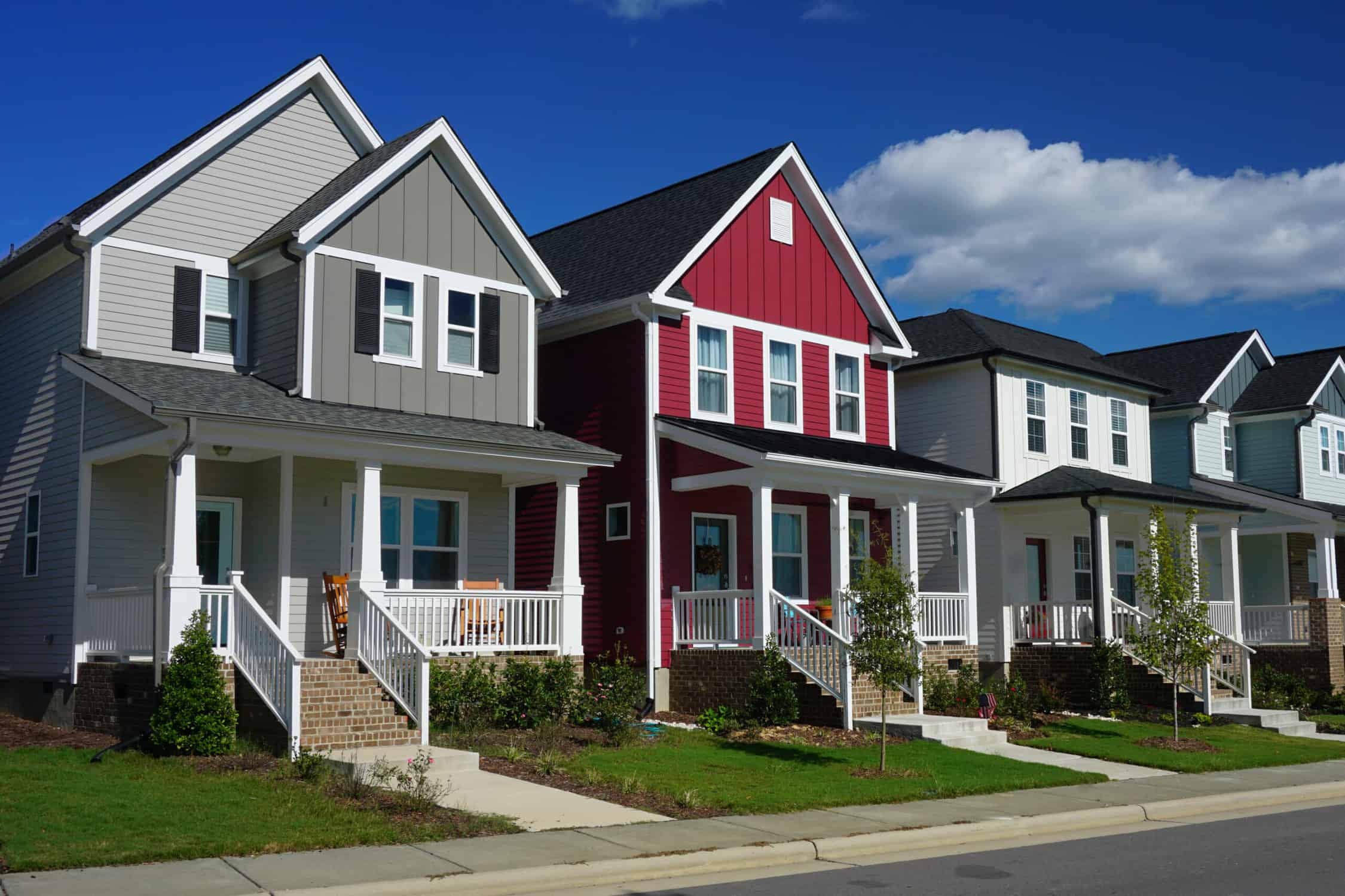 The front of each house has a porch, stairs and a sidewalk.