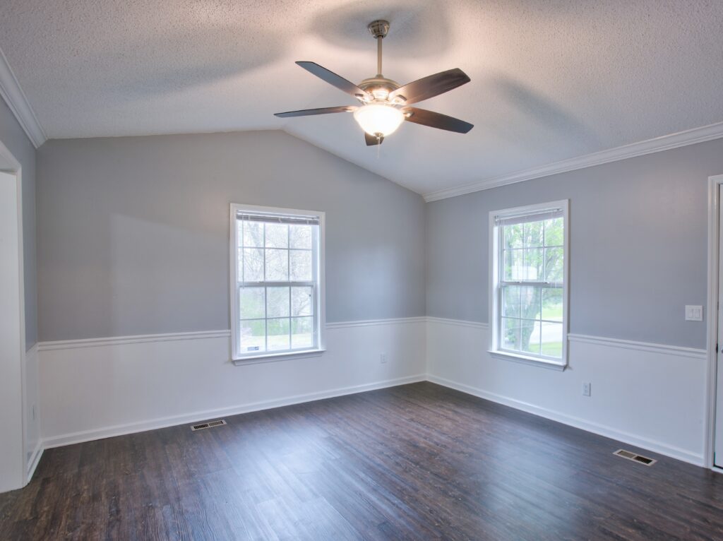 Gray living room interior with vaulted ceilings and chair rail.