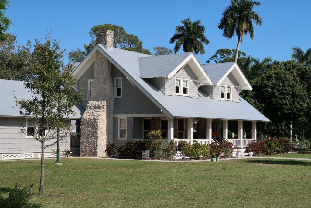 Light blue suburban house with stone chimney