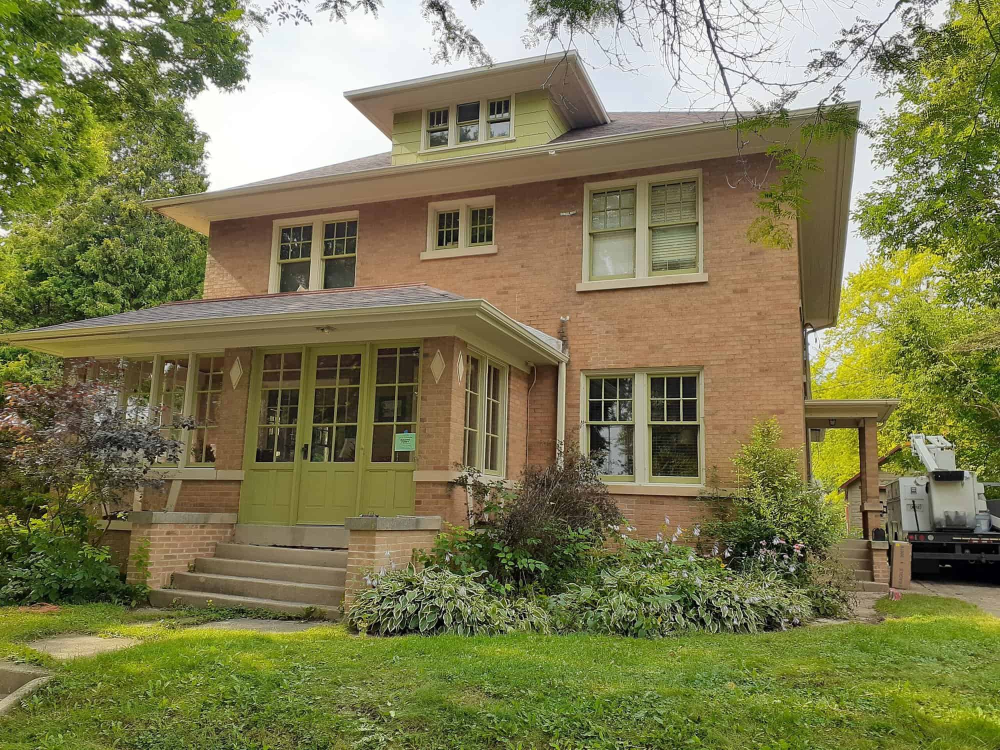 Brown house with elaborate garden and green door