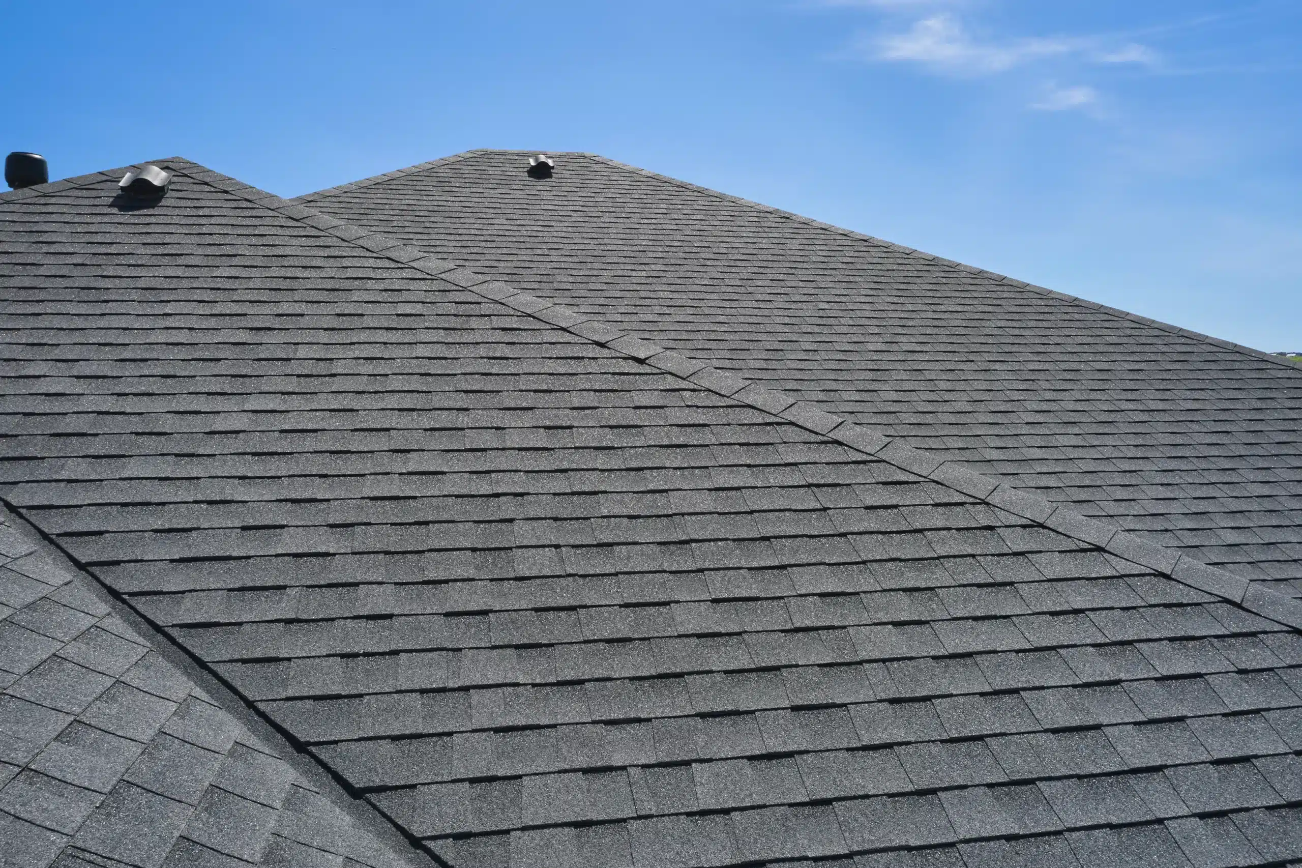 Expert Roof Cleaning and Exterior Painting Solutions Clean dark gray asphalt shingle roof on a residential home, showcasing excellent exterior maintenance and curb appeal.