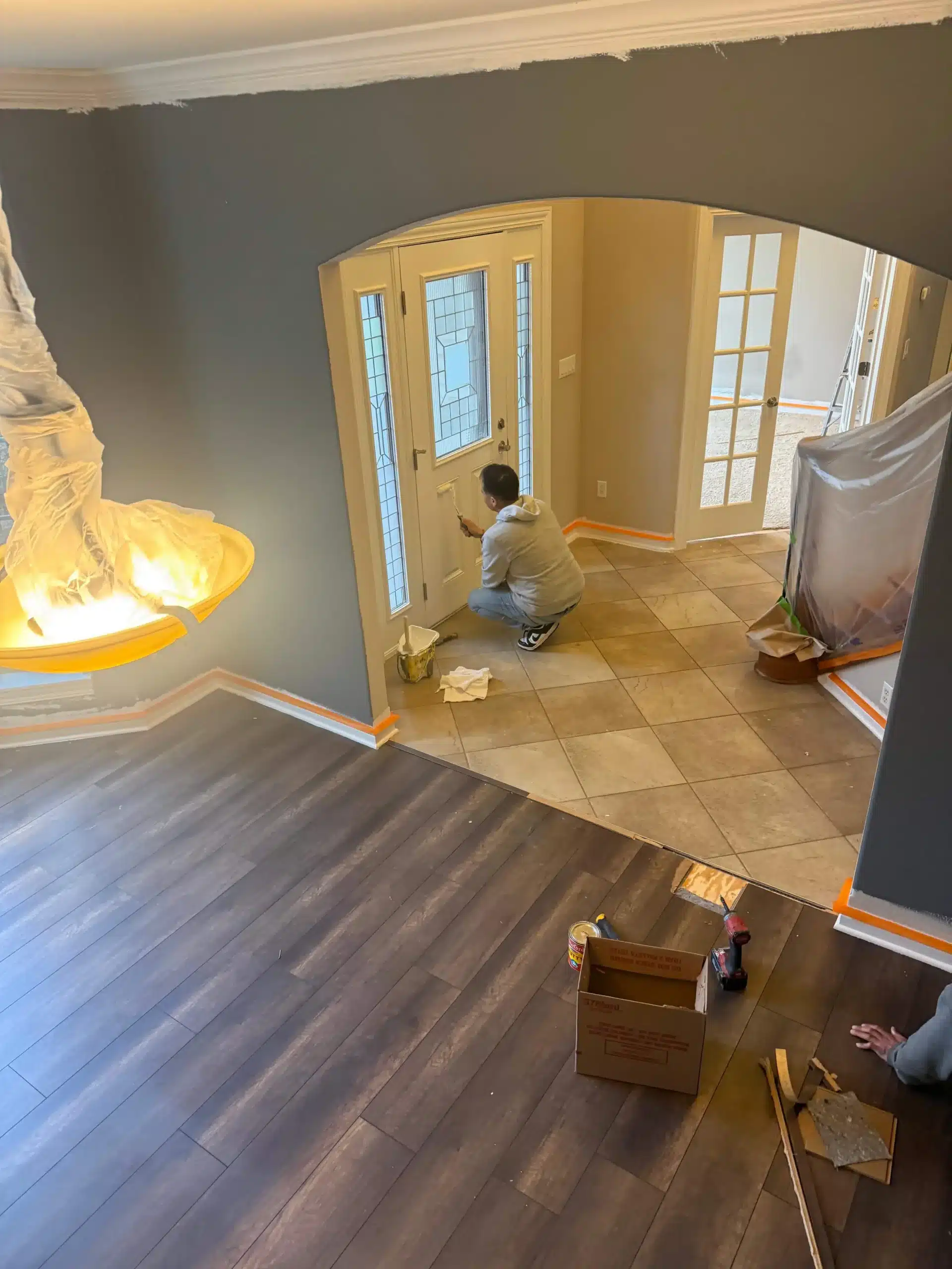 Expert Interior Door and Trim Painting Service Professional painter carefully applies white paint to an interior door and trim in a home entryway.